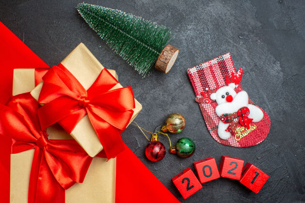 袜子圣诞背景与美丽的礼物蝴蝶结形丝带红色毛巾和数字xsmas袜子装饰配件在黑暗的桌子上夹子号码蝴蝶结