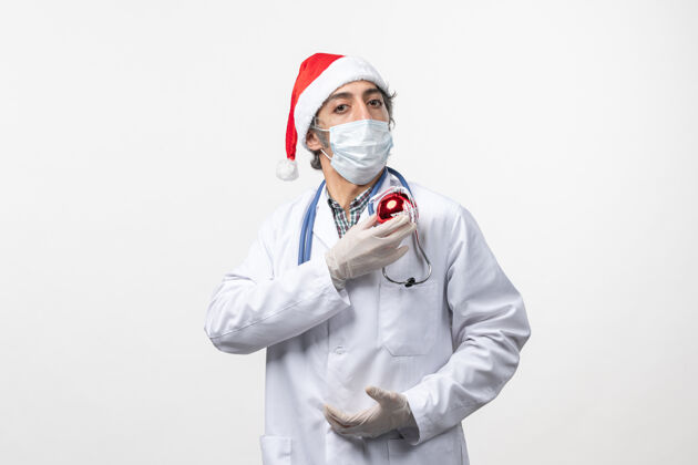 男医生正面图男医生戴着口罩带着玩具上白墙健康假日病毒实验室外套冠状病毒制服