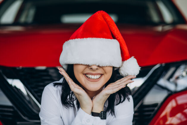 女商人圣诞节在汽车陈列室戴圣诞帽的女人彩票成人女人