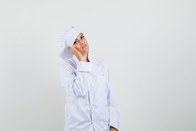 专业女厨师手拉手靠近脸颊穿着白色制服 看起来很自信亚洲工业女性