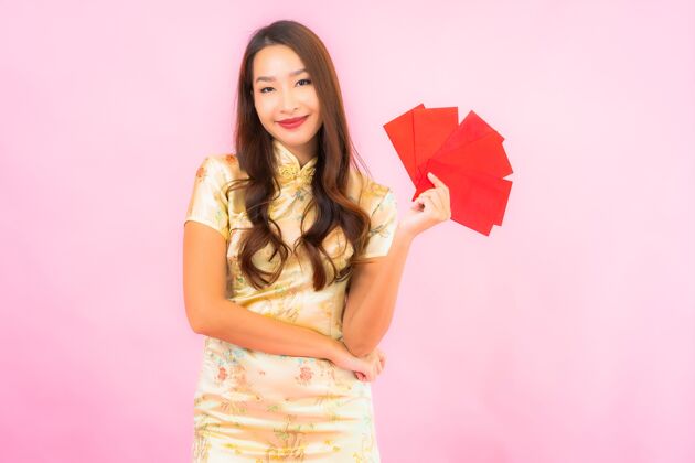 女性在粉红色的墙上画一幅美丽的亚洲年轻女子拿着红包女孩人脸