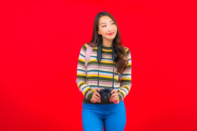 快乐在红色的隔离墙上 用相机背包和地图描绘美丽的亚洲年轻女子中国相机导游