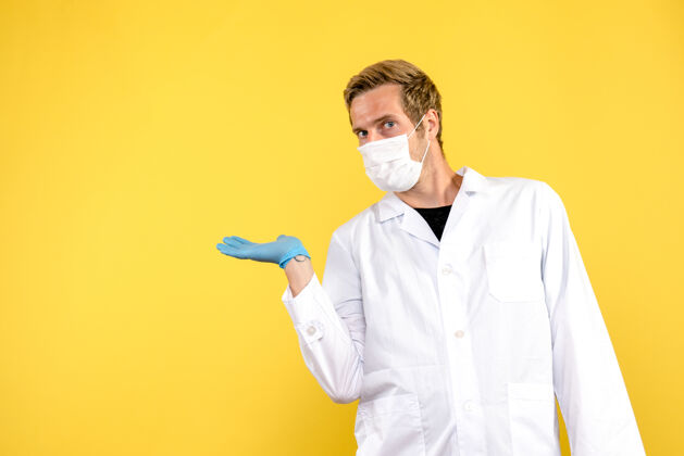 病毒正面图黄色背景上戴口罩的男医生健康病毒大流行大流行外观男性医生