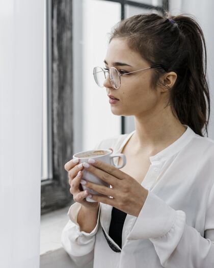 病毒在家里工作的女人手里拿着一杯咖啡呆在家里在家工作流行