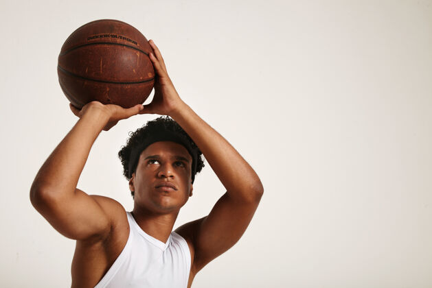 英俊一个穿着白色无袖衬衫的非洲裔美国球员准备扔掉一个旧的皮革篮球游戏比赛非洲