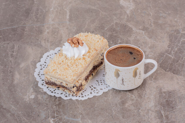 咖啡在大理石表面放一片蛋糕和一杯咖啡液体奶油美味