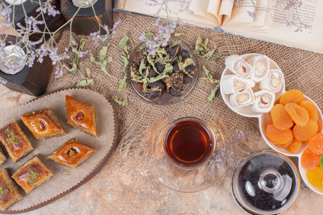 杏在大理石桌上放一杯茶 糖果和传统的各种烤肉杯子甜点Baklava