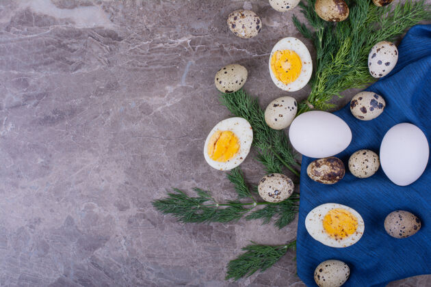 早午餐蓝毛巾上煮鸡蛋和生鸡蛋晚餐绿色顶部