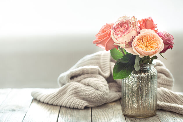 花束在木制桌子上的编织元素上 用玻璃花瓶中的花朵组成春天的构图温馨花朵新鲜