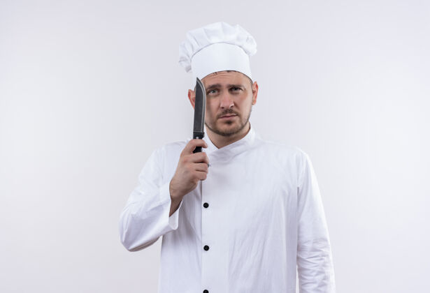 年轻体贴的年轻帅哥厨师穿着厨师制服拿着刀隔离在空白处制服厨师厨师
