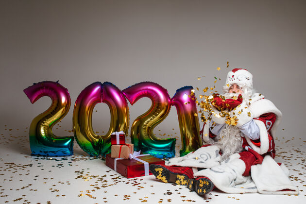 圣诞老人圣诞老人拿着礼物和气球坐在地上2021年服装圣诞2021