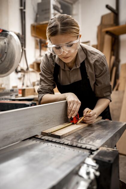 职业女木匠在工作室里用电锯工作职业木匠贸易