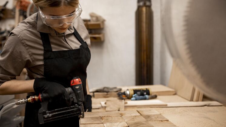 女性带气动订书机的女木匠侧视图职业工作技能
