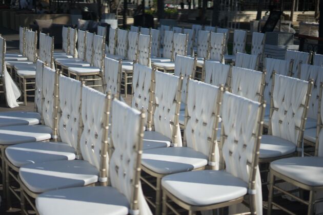 庆典特写镜头的白色椅子为客人的婚礼仪式桌布正式水