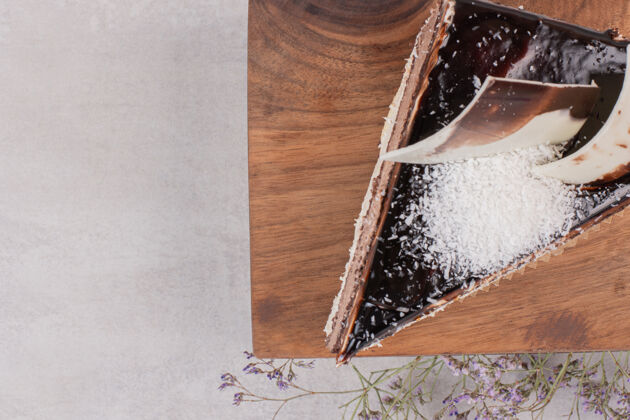 糖在木板上切一片巧克力蛋糕美味奶油顶部