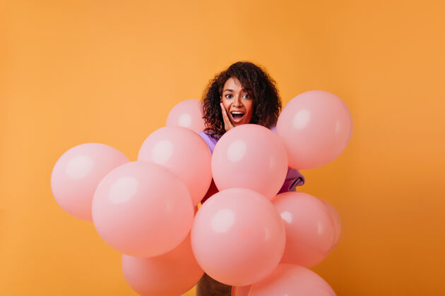成人可爱的黑人女子微笑着享受派对迷人的女模特站在橙色的气球上 粉红色的氦气球时尚礼物表情