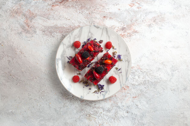 切片俯瞰美味的浆果蛋糕片与红色奶油白色背景浆果可食用水果可食用
