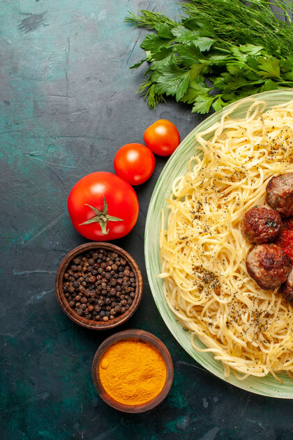 午餐俯瞰美味的意大利面食与肉丸和不同的调味品在深蓝色的背景蔬菜食物菜