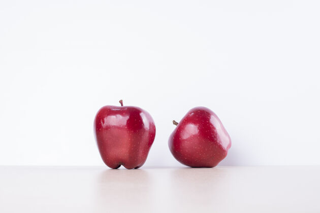 明亮白色表面上有两个红苹果维生素新鲜食物