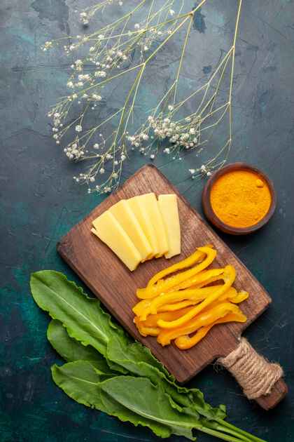 甜椒在深蓝色的桌子上俯瞰切碎的奶酪和切碎的黄甜椒膳食健康蔬菜