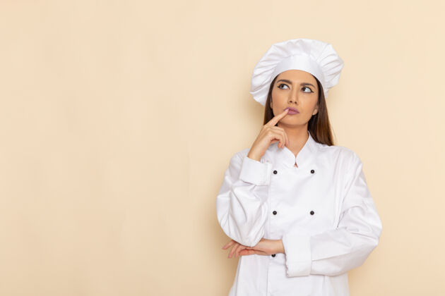 思考身着白色厨师服的年轻女厨师正对着浅白的墙壁思考肖像工人只是