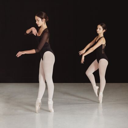 紧身衣专业芭蕾舞演员在尖头鞋一起练习的侧视图经典表演舞蹈