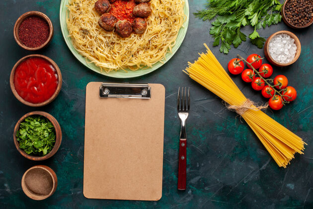 桌子在深蓝色的桌子上俯瞰美味的意大利面食 有肉丸和不同的调味品美味深色不同