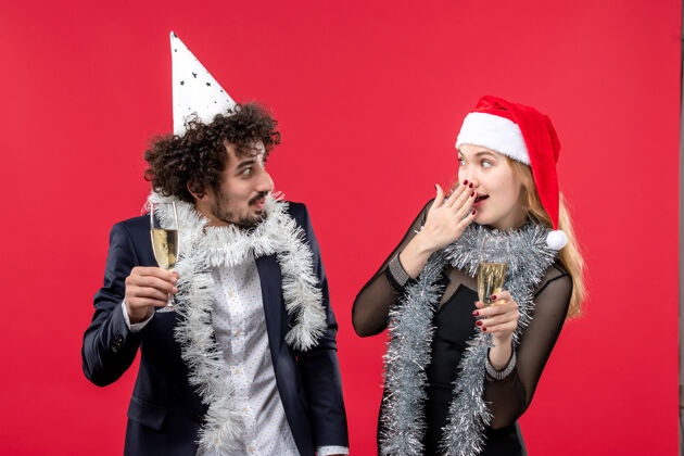 成人正面图：年轻夫妇在红桌假日爱情圣诞派对上庆祝新年漂亮黑发肖像