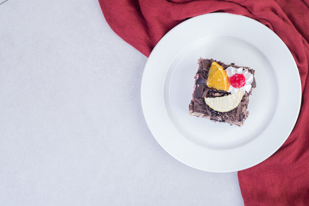 蛋糕用红桌布把巧克力蛋糕片放在白色盘子里甜点顶部视图切片