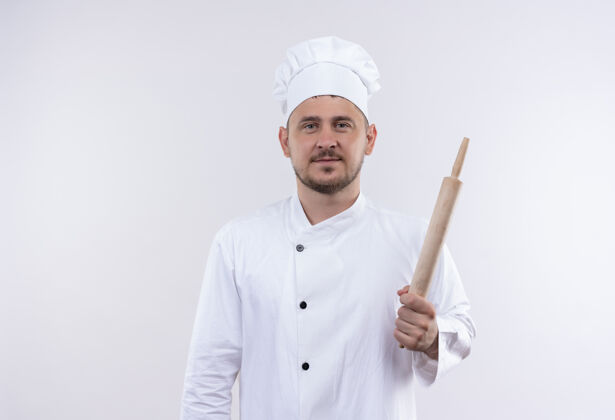 帅气高兴的年轻帅哥厨师穿着厨师制服拿着擀面杖隔离在空白处厨师厨师别针
