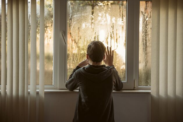 家庭站在窗户旁边的男孩Ncov检疫健康