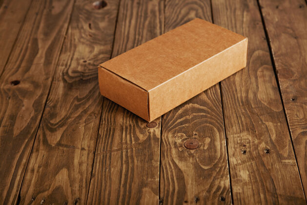 自然封闭的硬纸板包装盒呈现在强调拉丝木桌上 侧视图 中心隔离礼品里面的纸板