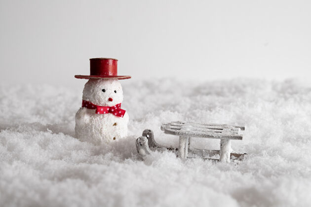 传统特写一个可爱的雪人玩具和雪地里的雪橇 季节礼物雪人