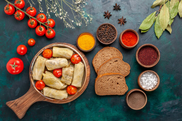 一餐俯瞰图美味的肉食卷心菜内卷面包和新鲜西红柿在深蓝色的桌子上桌子新鲜晚餐