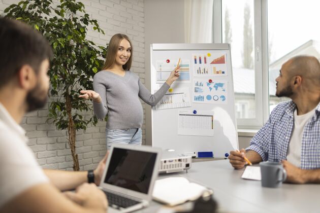 女性怀孕的女商人在办公室向男同事做报告男人水平笔记本电脑