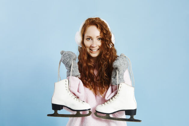 开朗微笑着拿着溜冰鞋的女孩的画像快乐冬天微笑