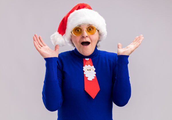 惊讶一位戴着太阳眼镜 戴着圣诞帽 系着圣诞领带的老太太大吃一惊新年老人一年