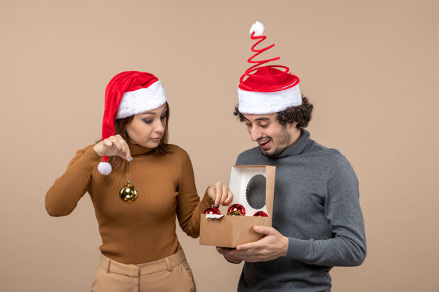 情侣喜庆的气氛与兴奋可爱的夫妇戴着红色圣诞老人帽的灰色镜头圣诞老人孩子镜头