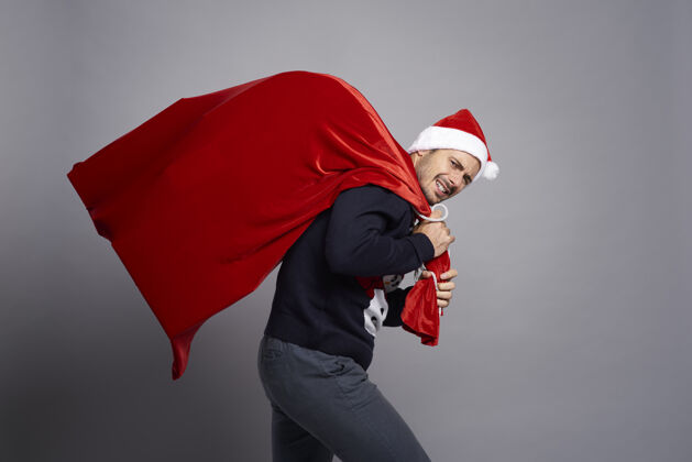 圣诞毛衣一个男人背着一个装满圣诞礼物的大袋子情侣圣诞脸