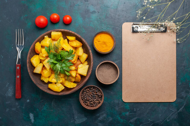 健康在深蓝色的背景上 俯瞰美味的熟土豆 调味料和记事本柑橘记事本配料