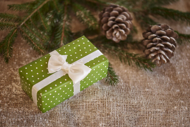 松树包装好的圣诞礼物和松果的照片关闭桌子现代