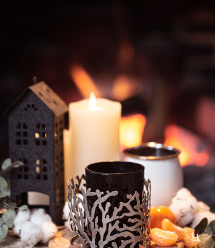 合成静物画 热饮 蜡烛和装饰在熊熊燃烧的火堆上晚上在壁炉旁放松的概念温暖橘子乡村