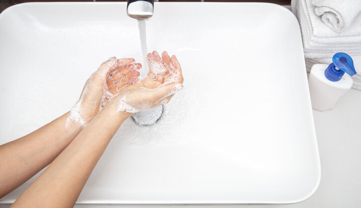 护理在自来水下用肥皂水洗手个人卫生和健康的概念手洗涤卫生