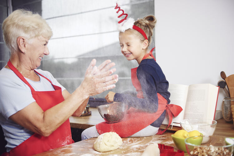 饼干奶奶和孙女在厨房里玩得很开心团队合作家庭面粉