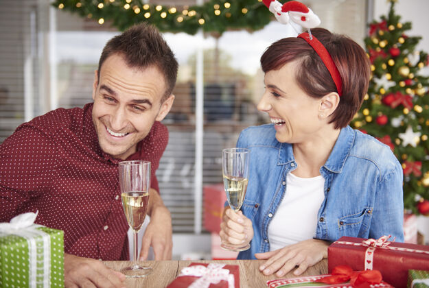 圣诞树这对夫妇笑了笑 坐在桌子旁边腰向上特写关合