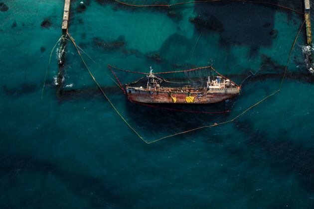 航拍一艘搁浅并翻倒的旧油轮的俯视图货物海洋废弃