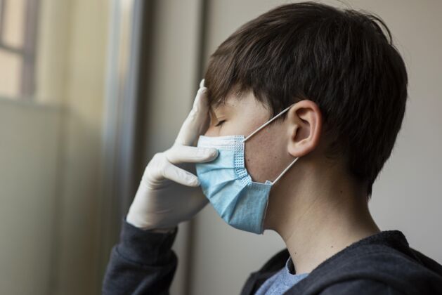 流行戴着医用口罩的男孩摸他的脸检疫Ncov呆在家里