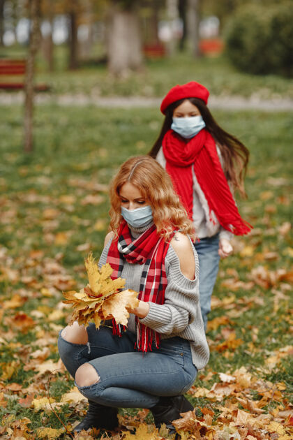 护理秋天公园里的一家人冠状病毒主题母亲带女儿人家庭坏