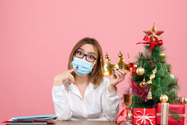圣诞节女工坐在粉红色的无菌口罩里的正视图办公室女工工作