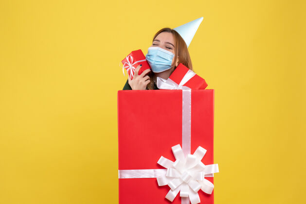 Covid正面图年轻女性在无菌口罩礼品盒内与礼物礼物年份圣诞节